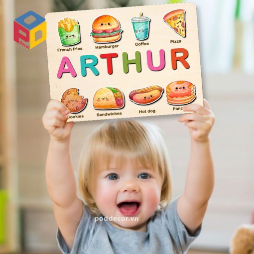 Em bé với bảng tên chủ đề thức ăn nhanh - đồ chơi trẻ em