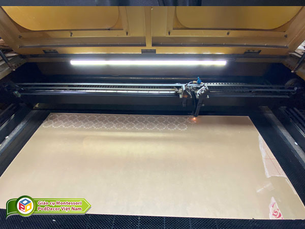 Máy laser của PodDecor Việt Nam đang thực hiện cắt mica theo yêu cầu của khách hàng